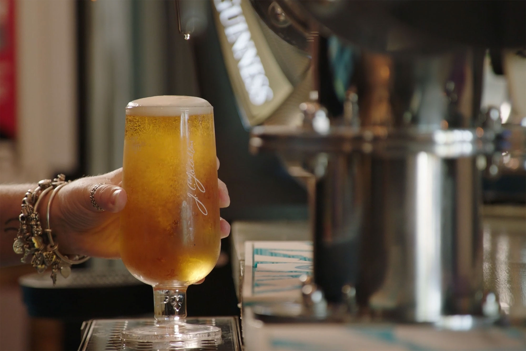 A person holding a glass of beer