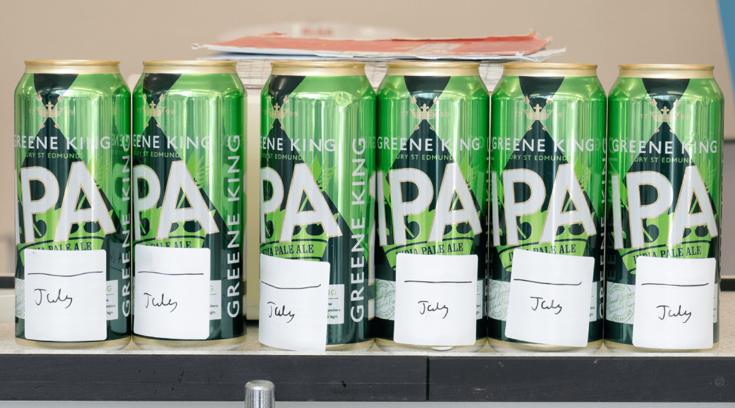 A selection of Greene King IPA cans with the date July